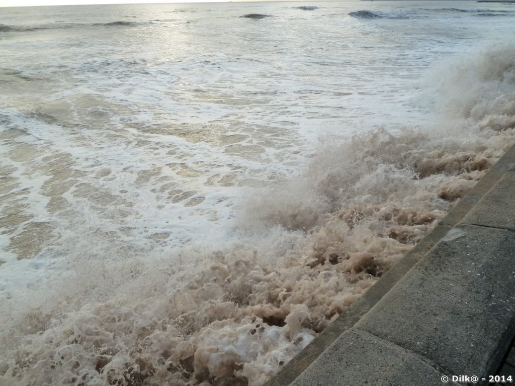 Les vagues montent jusqu'au mur de la promenade côtière
