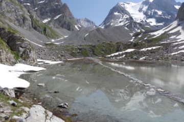 Le lac des Vaches avec les reflets de la Grande Casse et le passage à gué sur des dalles