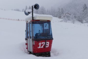 La télécabine posée sur la neige sert d’abri au gardien de la piste de snowtube