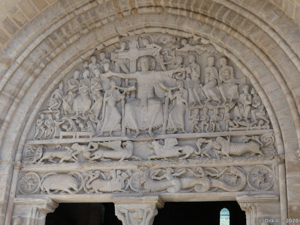 Le tympan de l'église abbatiale Saint-Pierre évoque les trois mondes : le ciel, la terre et l'enfer