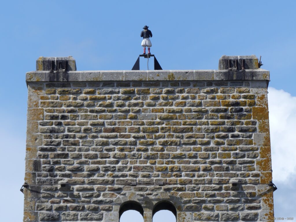 Statue en résine représentant le Bonhomme en haut d'une des piles du pont