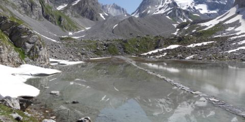 Le lac des Vaches avec les reflets de la Grande Casse et le passage à gué sur des dalles